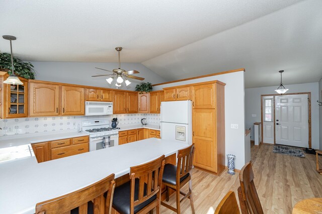 kitchen with light wood-type flooring, white appliances, a peninsula, light countertops, and glass insert cabinets