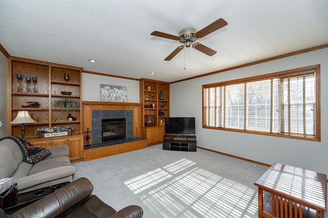 living area with a glass covered fireplace, baseboards, light carpet, and ornamental molding