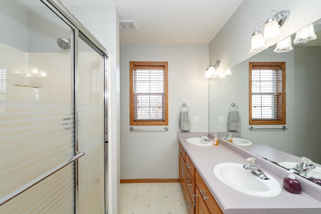 bathroom with a healthy amount of sunlight, visible vents, and a sink