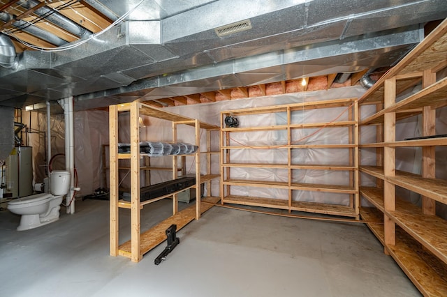 unfinished basement with visible vents and water heater