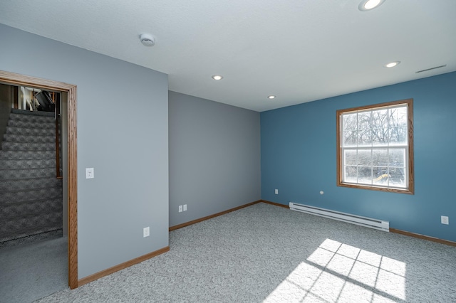 unfurnished room featuring a baseboard heating unit, baseboards, carpet, and stairs