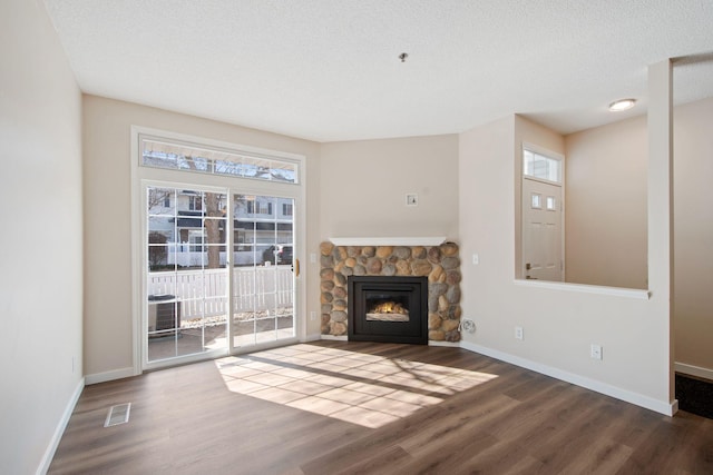 unfurnished living room with wood finished floors, visible vents, and a wealth of natural light