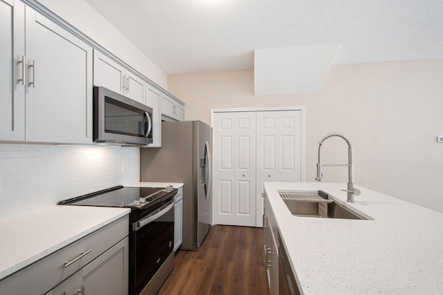 kitchen featuring a sink, stainless steel microwave, gray cabinetry, and range with electric cooktop