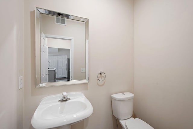 bathroom with a sink, visible vents, and toilet