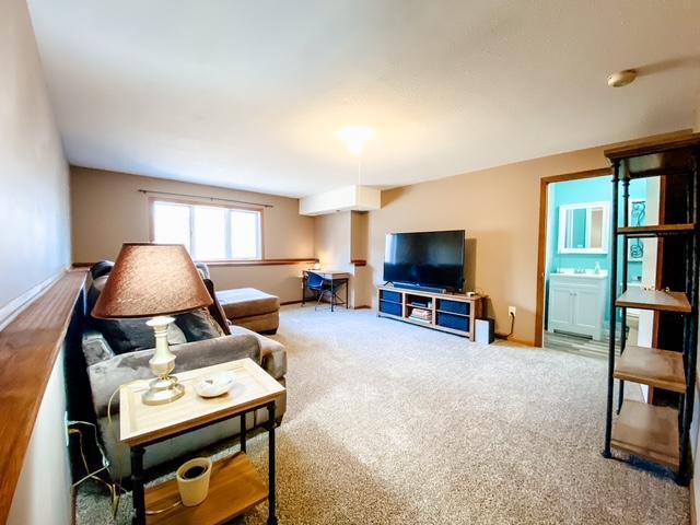 carpeted living room with baseboards