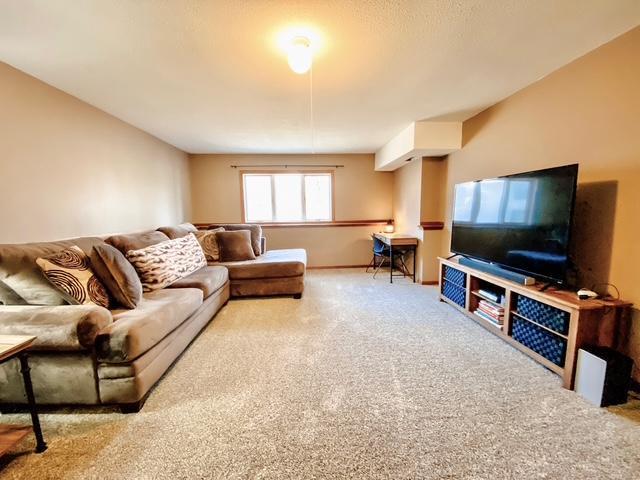 carpeted living room with baseboards