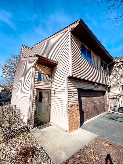 exterior space featuring brick siding and an attached garage