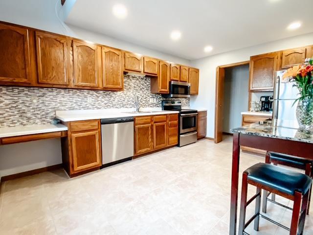 kitchen with a sink, stainless steel appliances, tasteful backsplash, and recessed lighting