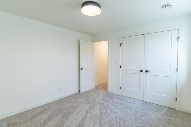 unfurnished bedroom with baseboards, a closet, and carpet floors