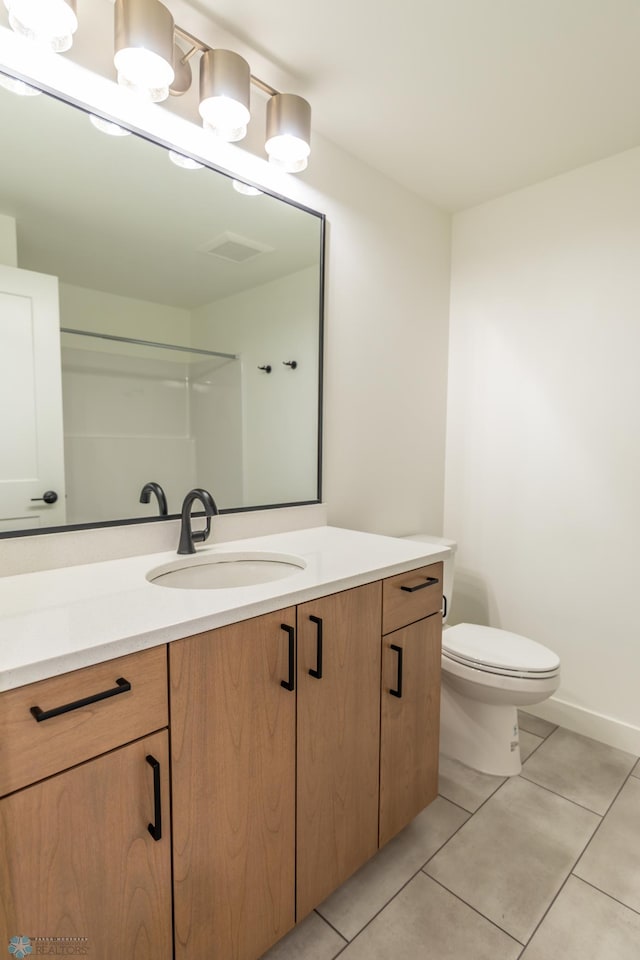 bathroom featuring vanity, toilet, baseboards, tile patterned floors, and visible vents