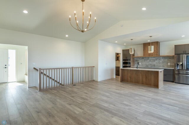 kitchen with decorative backsplash, light countertops, modern cabinets, stainless steel appliances, and light wood-style floors