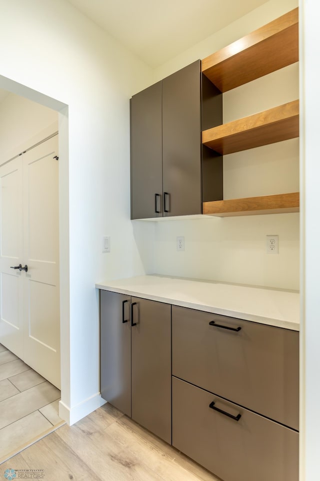kitchen featuring light countertops, light wood-style flooring, and gray cabinets