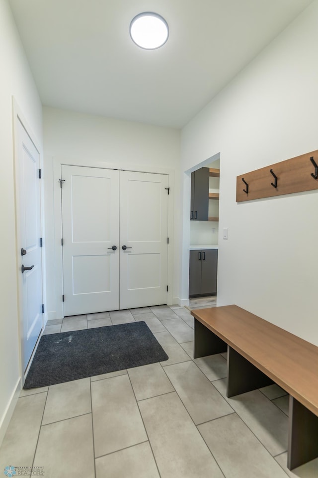 mudroom featuring light tile patterned floors and baseboards