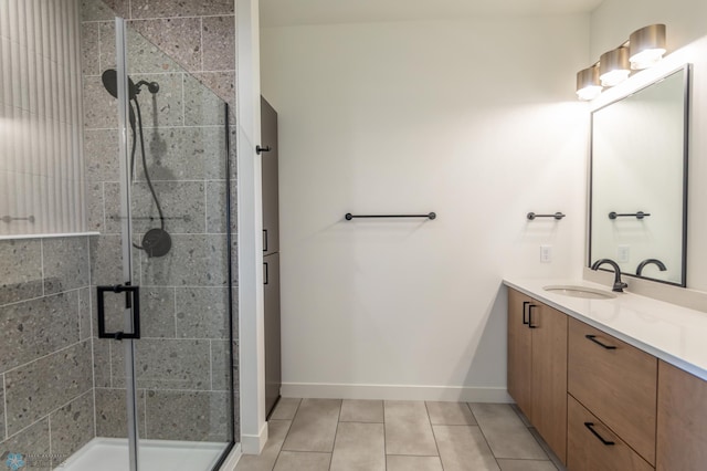 bathroom featuring a stall shower, tile patterned floors, baseboards, and vanity
