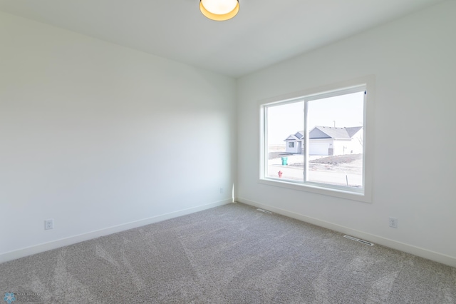 empty room featuring baseboards, carpet flooring, and visible vents