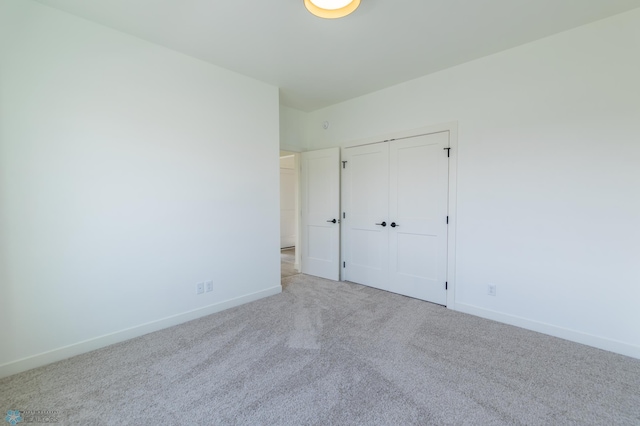 unfurnished bedroom with baseboards, a closet, and carpet flooring