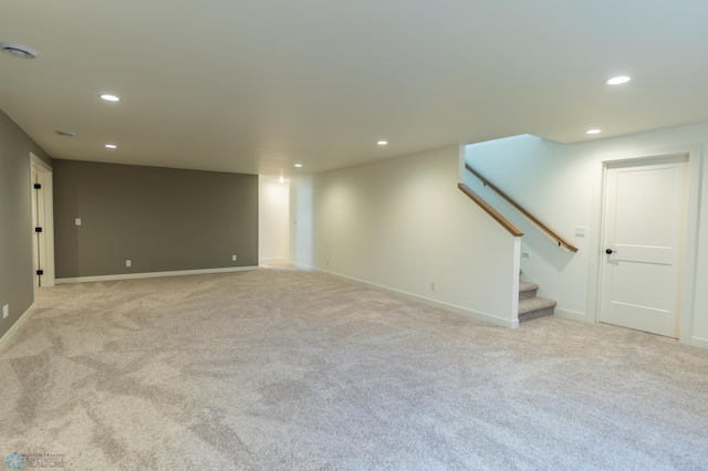 empty room featuring baseboards, stairway, recessed lighting, and light carpet
