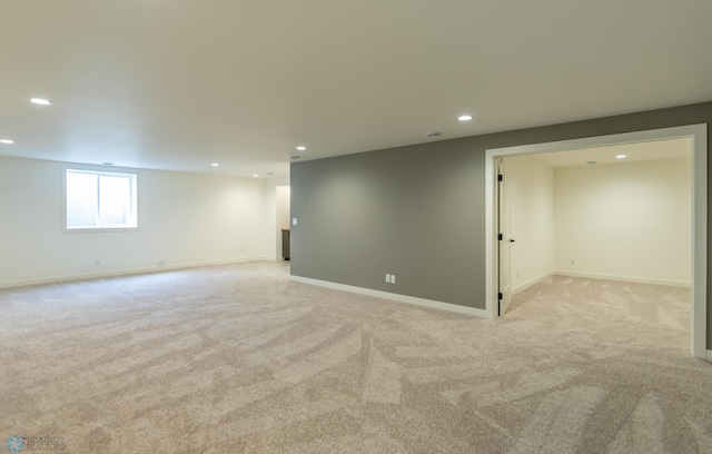 below grade area with light colored carpet, baseboards, and recessed lighting