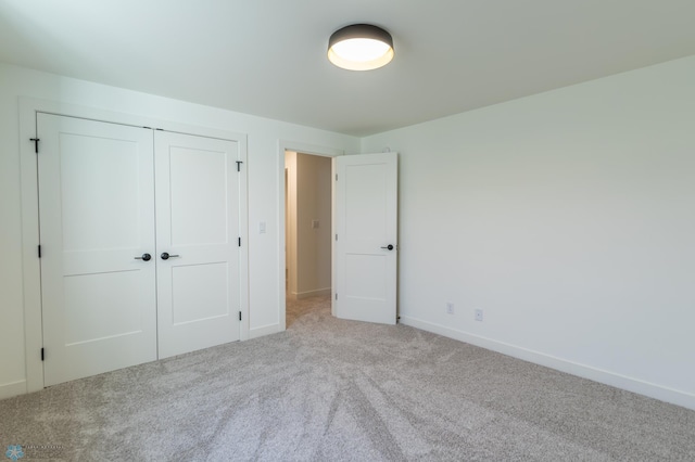 unfurnished bedroom featuring baseboards, a closet, and carpet floors