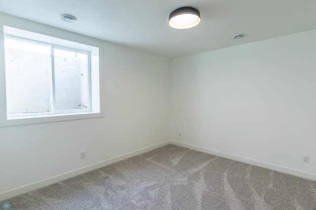 carpeted empty room featuring baseboards and a healthy amount of sunlight