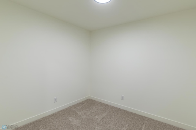 unfurnished room with baseboards and light colored carpet