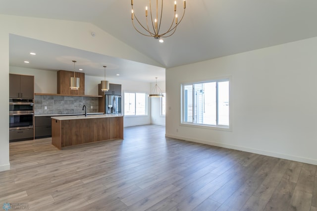 8319 59th St S, Horace, ND 58047 - kitchen featuring appliances with stainless steel finishes, a chandelier, open floor plan, lofted ceiling, and light countertops