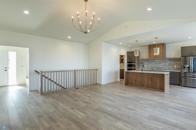 8319 59th St S, Horace, ND 58047 - kitchen featuring appliances with stainless steel finishes, modern cabinets, light countertops, vaulted ceiling, and tasteful backsplash