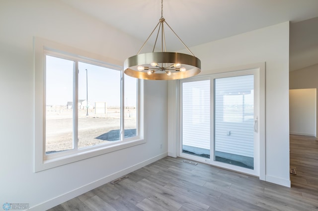 8319 59th St S, Horace, ND 58047 - unfurnished dining area featuring a chandelier, healthy amount of natural light, and wood finished floors