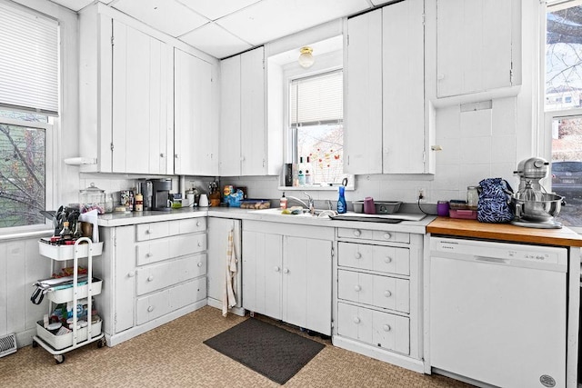 kitchen featuring a sink, white cabinetry, light countertops, and white dishwasher