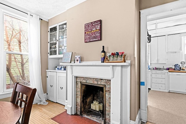 interior space with a textured ceiling, wood finished floors, and a tile fireplace