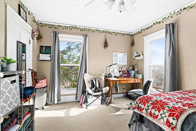 bedroom featuring a ceiling fan, a textured ceiling, and carpet flooring