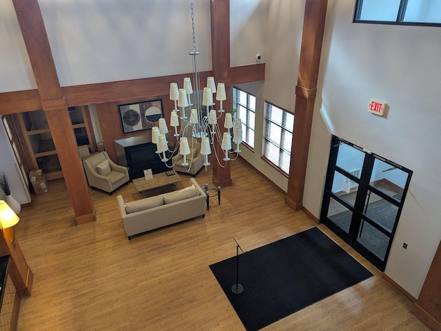 13580 Technology Dr Unit 3202, Eden Prairie, MN 55344 - living room with a towering ceiling, decorative columns, wood finished floors, a chandelier, and baseboards