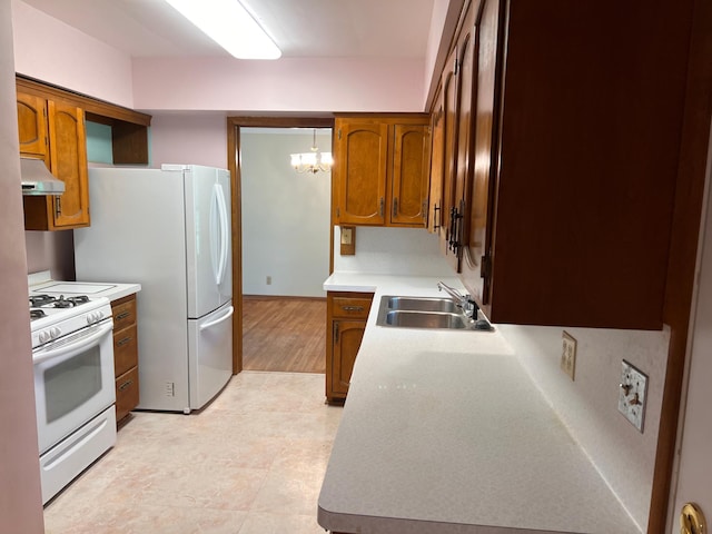 1711 Winnetka Ave N, Golden Valley, MN 55427 - kitchen with under cabinet range hood, white appliances, brown cabinetry, light countertops, and a chandelier
