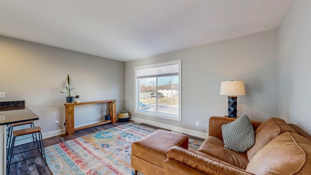 living area with baseboards and wood finished floors