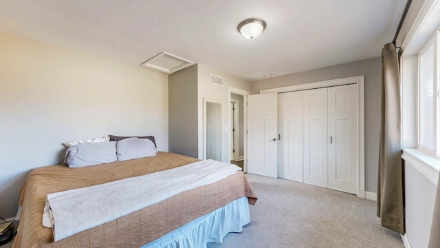 carpeted bedroom featuring visible vents, attic access, and a closet