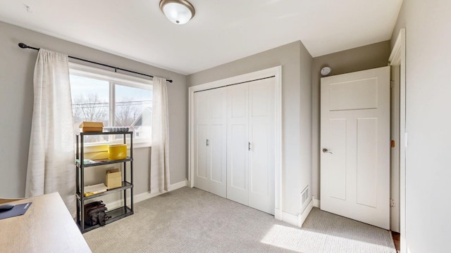 bedroom with visible vents, light colored carpet, a closet, and baseboards