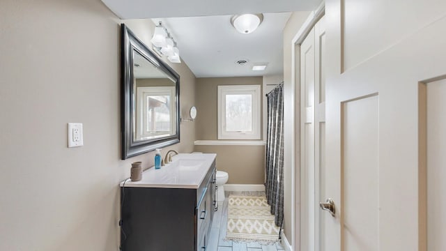 bathroom featuring vanity, visible vents, baseboards, curtained shower, and toilet