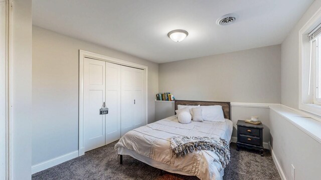 bedroom with visible vents, baseboards, carpet, and a closet