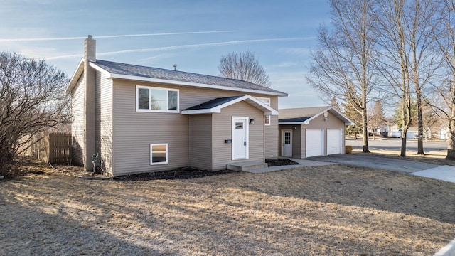 view of front facade featuring a garage, driveway, and fence