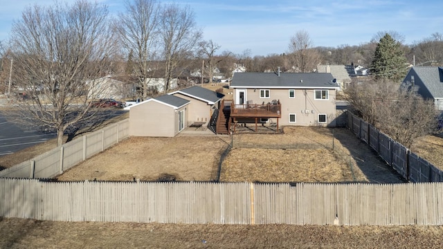 back of property featuring a deck, stairs, and a fenced backyard