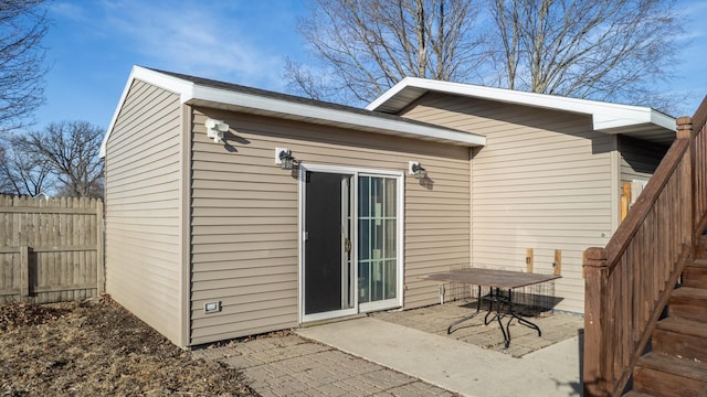 rear view of house with a patio and fence