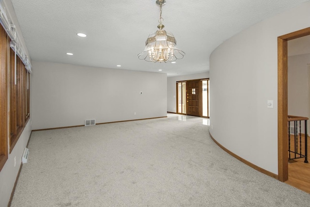 spare room with baseboards, visible vents, recessed lighting, a textured ceiling, and light carpet