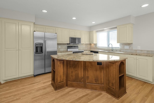 kitchen with a sink, light wood-style flooring, a center island, and stainless steel appliances