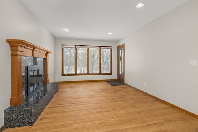 living room with recessed lighting, light wood-style flooring, a fireplace, and baseboards