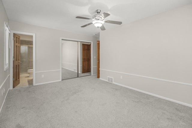 unfurnished bedroom with visible vents, baseboards, carpet, a closet, and ensuite bath