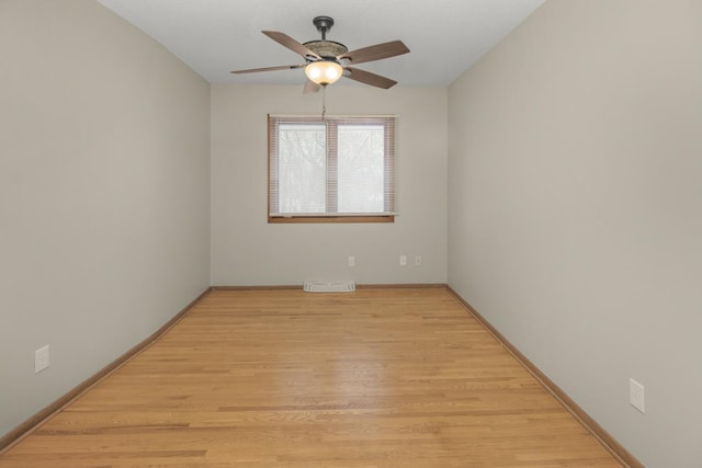 unfurnished room featuring baseboards, light wood-style floors, visible vents, and ceiling fan