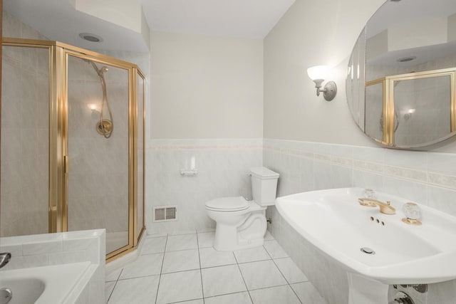 full bath with visible vents, a stall shower, a sink, tile patterned floors, and a bathtub