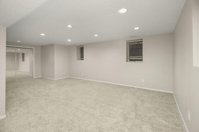 spare room with recessed lighting, a textured ceiling, baseboards, and carpet floors