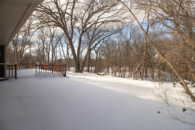 yard layered in snow featuring a wooden deck