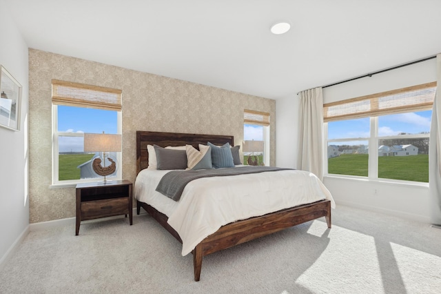 bedroom with baseboards, light carpet, and wallpapered walls